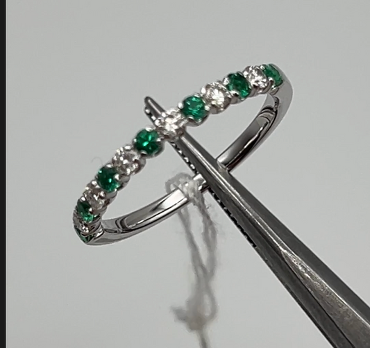 Luxurious 14k white gold eternity band featuring alternating emeralds and diamonds, embodying classic elegance with a modern twist.