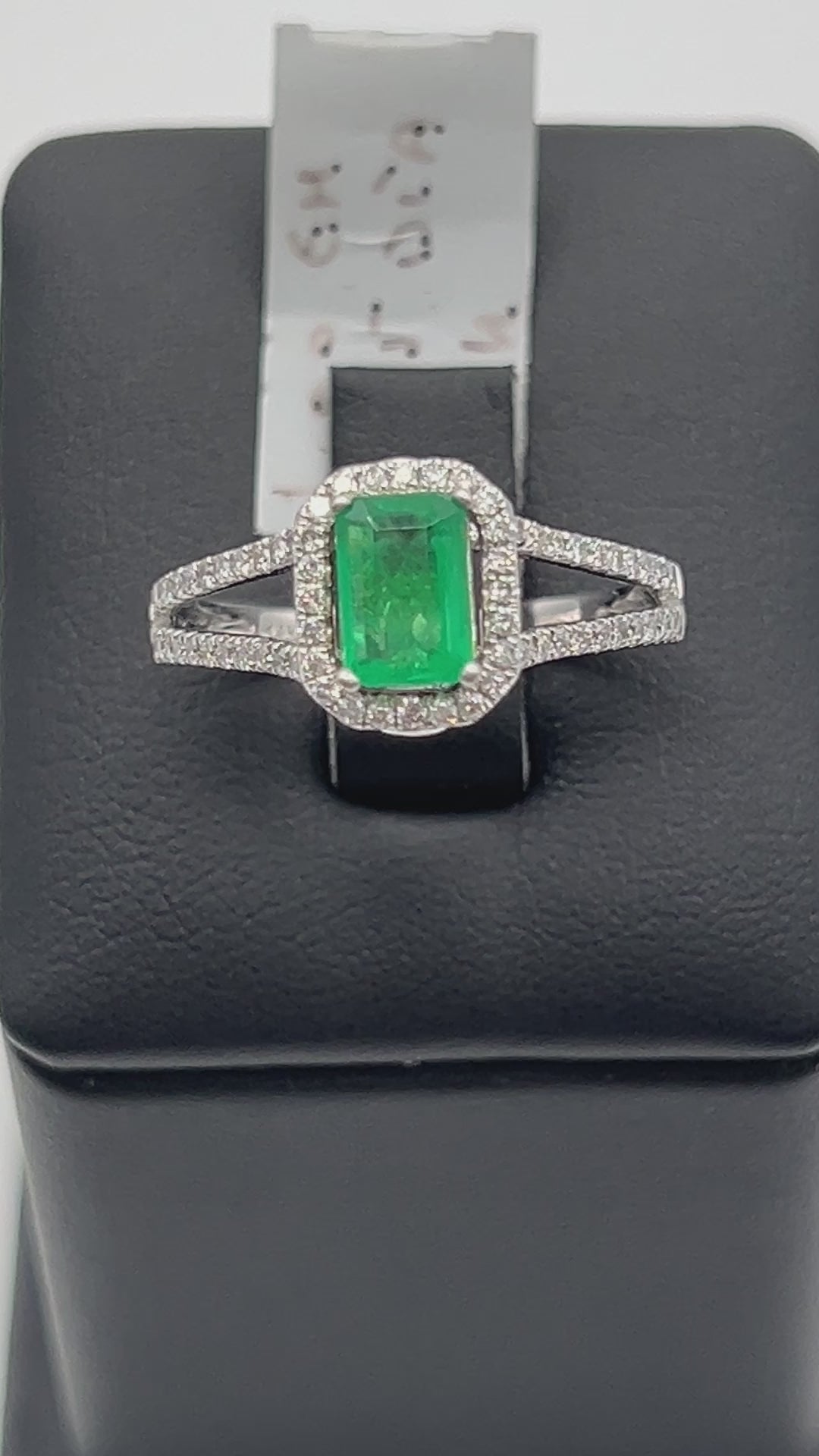 A noisy video of a Stunning 1 Ct natural emerald ring with 2.33 Ct diamond halo set in a sophisticated 14k white gold band, embodying luxury and style.